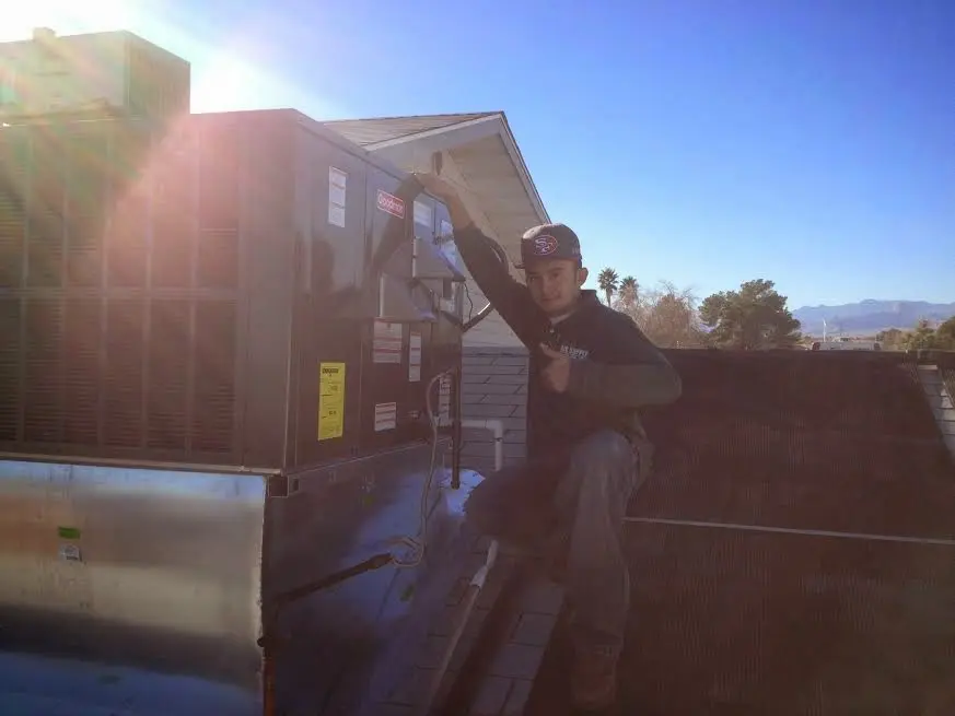 HVAC technician performing Boiler Repair on a rooftop unit in Urbana